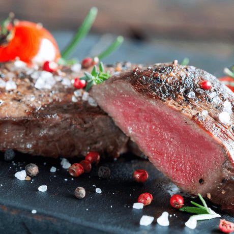 Medium rare gebratenes Hüftsteak auf einem rustikalen Teller, mit einem perfekten rosa Zentrum, umgeben von einer leichten Kruste, garniert mit frischen Kräutern